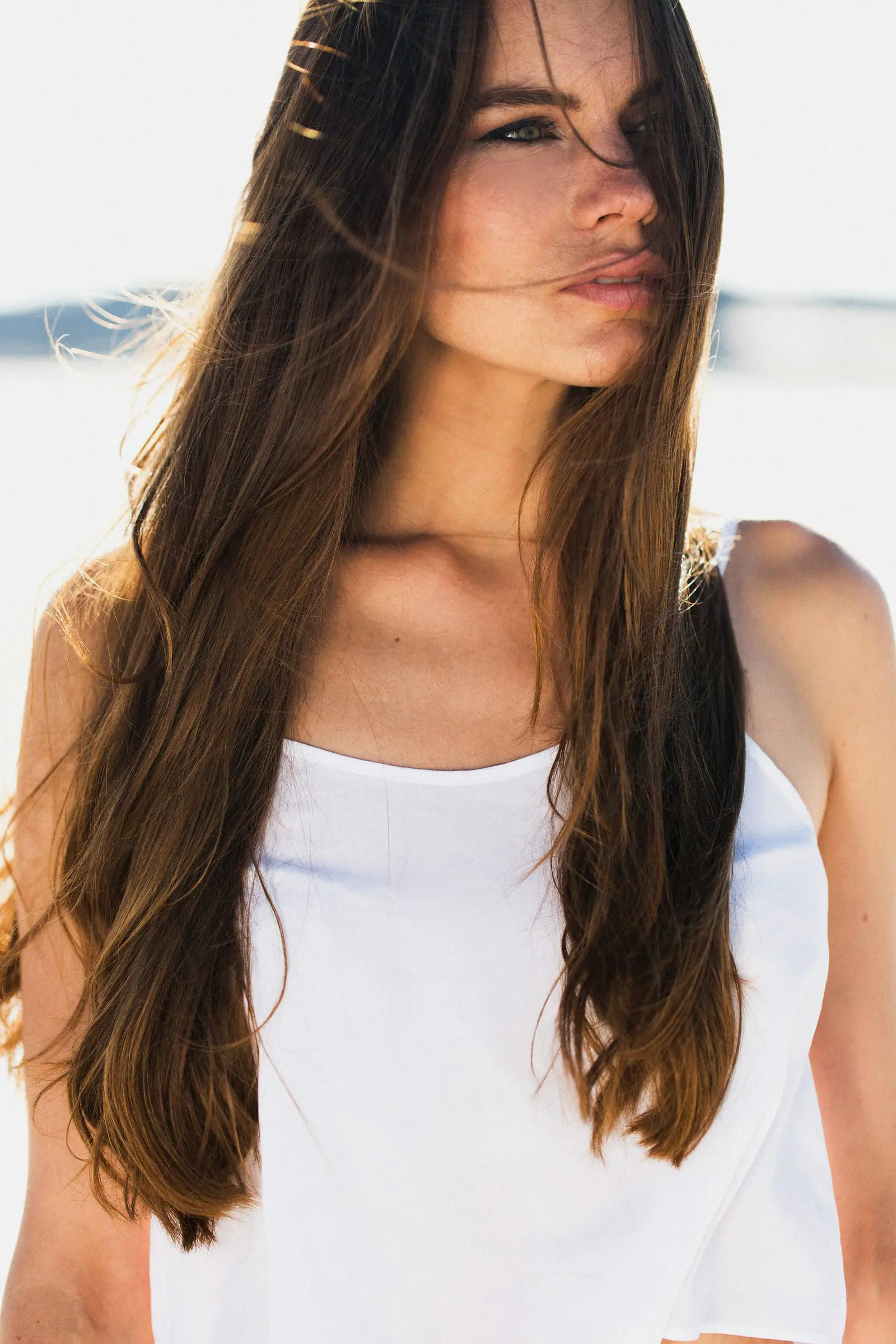 A woman with bare skin and undone hair, looking away from camera.